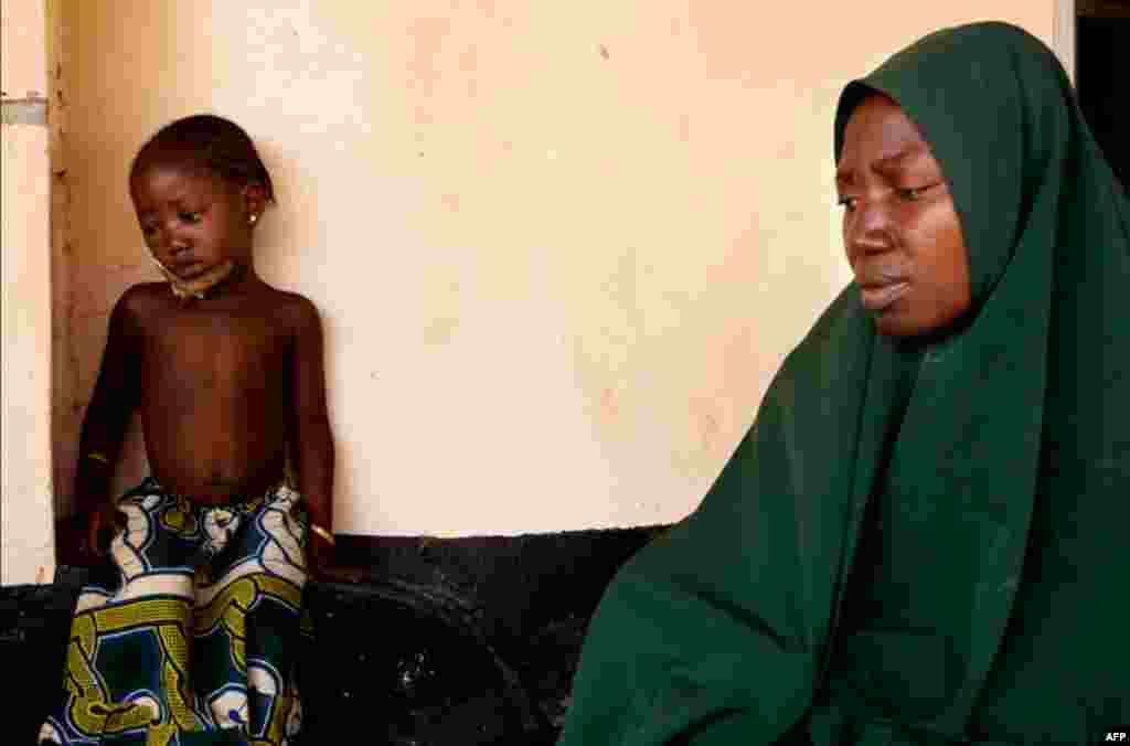 April 20: Amina Usman and her daughter Rabi, a victim of postelection violence, wait for treatment at St. Gerard's Hospital in Kaduna, Nigeria. In the hospital's morgue lay the bodies of victims shot and burned in rioting that swept Kaduna in the aftermat