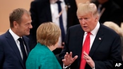 U.S. President Donald Trump, right, gestures as he talks to German Chancellor Angela Merkel, center, and European Council President Donald Tusk, left, during a working session at the G-20 summit in Hamburg, northern Germany.