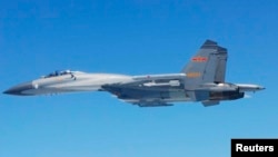 FILE - A Chinese SU-27 fighter flies over the East China Sea, in this handout photo taken May 24, 2014 and released by the Defense Ministry of Japan, May 25, 2014. 