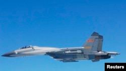 A Chinese SU-27 fighter flies over the East China Sea, in this handout photo taken May 24, 2014 and released by the Defense Ministry of Japan, May 25, 2014. 