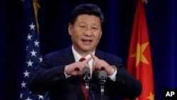 22일 미국 서부 워싱턴 주에 도착한 시진핑 중국 국가주석이 시애틀에서 열린 연회에서 중국어 '사람' 글자를 손가락으로 만들어 보이고 있다. 시 주석은 중국어 '사람'은 두 개의 막대기가 서로 기댄 모습이라고 설명하고 있다.