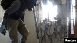 29일 시리아 다마스쿠스 외곽 자말카에서 유엔 소속 전문가 방독면을 쓴 채 화학무기 공격 현장을 조사하고 있다.