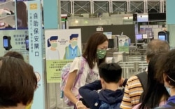 有香港家长带同年幼子女移民，在香港国际机场离境时与亲友依依惜别。（美国之音 / 汤惠芸）