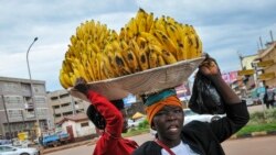 FILE - Women sell bananas on a street in Kampala, Uganda, March 26, 2020. 