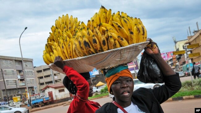 FILE - Women sell bananas on a street in Kampala, Uganda, March 26, 2020.
