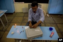 A polling officer seals an electronic voting machine at the end of the first phase of elections at a polling booth in Hyderabad, India, April 11, 2019.
