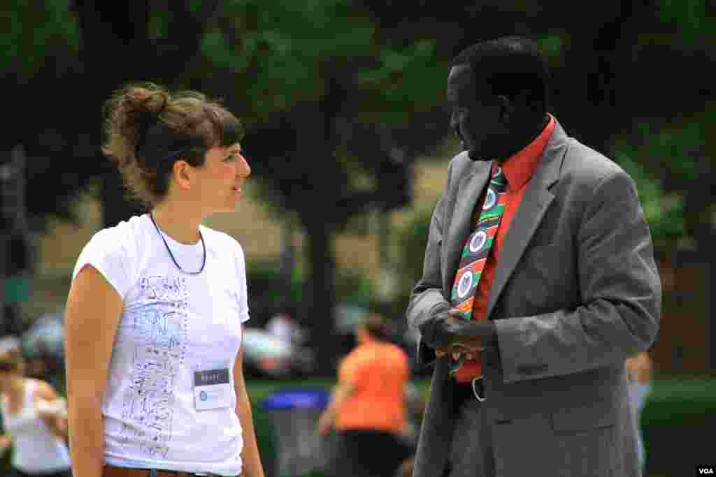 A South Sudanese man speaks with a project staff member at the &quot;One Million Bones&quot; installation on the National Mall, Washington, D.C, June 8, 2013. (Jill Craig/VOA)
