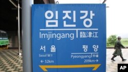 Binh sĩ Nam Triều Tiên đi ngang qua bảng chỉ đường cho thấy khoảng cách từ ga Imjingang đến Bình Nhưỡng, ngày 12/6/2013. 