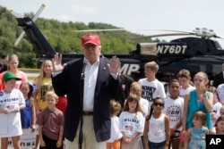 FILE: Then-presidential candidate Donald Trump talks to the media after arriving by helicopter at a nearby ballpark before Trump attended the Iowa State Fair Saturday, Aug. 15, 2015, in Des Moines. (AP Photo/Charlie Riedel)