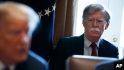 FILE - National security adviser John Bolton listens as President Donald Trump speaks during a cabinet meeting at the White House in Washington, April 9, 2018.