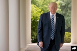 President Donald Trump walks along the West Wing Colonnade at the White House in Washington, April 21, 2017.