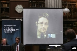 FILE - National Security Agency leaker Edward Snowden speaks via video link during the Athens Democracy Forum, organized by The New York Times, at the National Library in Athens, Sept. 16, 2016.