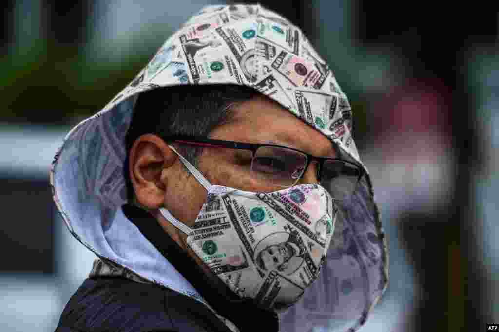 Човек со маска присуствува на протест во Мајами на кој се бара отворање на Флорида. (CHANDAN KHANNA / AFP)