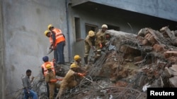Tim penyelamat membongkar timbunan puing beton dan abu mencari orang yang selamat 5 Januari 2014. 