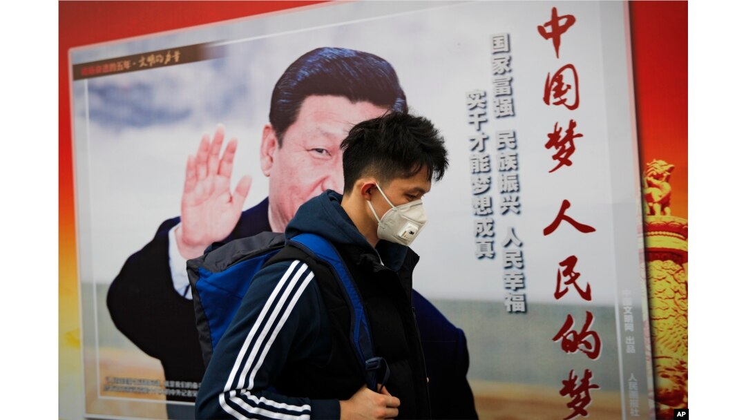 北京街道上，戴口罩的行人走过带有中国领导人习近平像的海报，海报上有标语“中国梦人民的梦”（2017年10月26日）