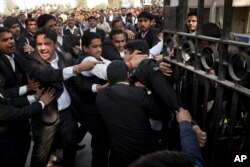 A lawyer, center, who spoke to the media supporting student leader Kanhaiya Kumar, is beaten up by other lawyers outside a Delhi court, in New Delhi, India, Feb. 17, 2016.