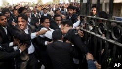 A lawyer (c) who spoke to the media supporting student leader Kanhaiya Kumar, is beaten up by other lawyers outside a Delhi court, in New Delhi, India, Feb. 17, 2016. 
