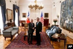 El secretario del Tesoro de EE.UU., Steven Mnuchin (izq.) y el presidente de Chile, Sebastián Piñera, saludan antes de iniciar un diálogo en el palacio presidencial de la Moneda en Santiago de Chile. Marzo 21 de 2018.