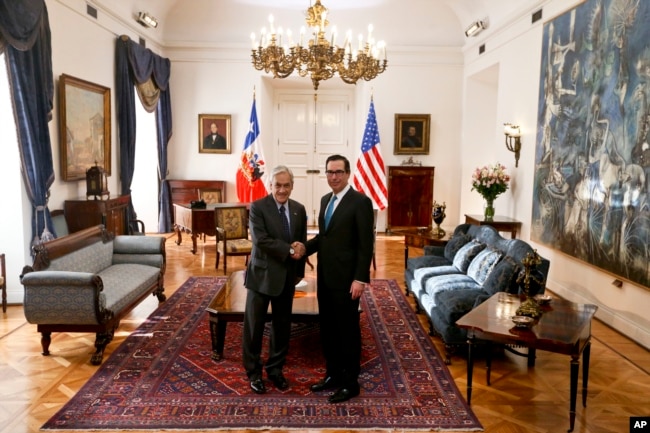 El secretario del Tesoro de EE.UU., Steven Mnuchin (izq.) y el presidente de Chile, Sebastián Piñera, saludan antes de iniciar un diálogo en el palacio presidencial de la Moneda en Santiago de Chile. Marzo 21 de 2018.