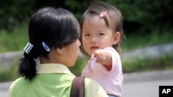 FILE - A North Korean defector carries a baby at the South Korean Hanawon resettlement facility in Anseong, 77 kilometers south of Seoul.