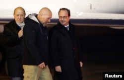 FILE - Former hostage Serge Lazarevic (C) talks with then-French president Francois Hollande (R) and then-defense minister Jean-Yves Le Drian at his arrival at a military airport near Paris, France, Dec 10, 2014. Lazarevic had been kidnapped by al-Qaida militants in Mali. Hollande denied the French government paid a ransom for his release.