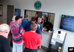 FILE - People line up to be among the first in Nevada to legally purchase medical marijuana at the Silver State Relief dispensary in Sparks, Nev. Nevada's marijuana regulators began recreational sales July 1, 2017.