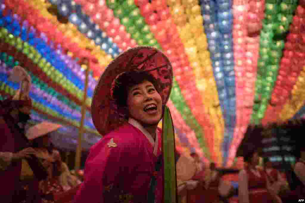 A reveler dances beneath lanterns at the Jogye buddhist temple following a lantern parade as part of a &#39;Lotus Lantern Festival&#39; celebrating the upcoming Buddha&#39;s birthday, in Seoul, South Korea, May 12, 2018.