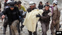 Des membres de la défense civile syrienne, connus sous le nom de Casques blancs, retirent une victime des décombres d'un bâtiment détruit suite à une attaque aérienne à Idlib, Syrie, 15 mars 2017