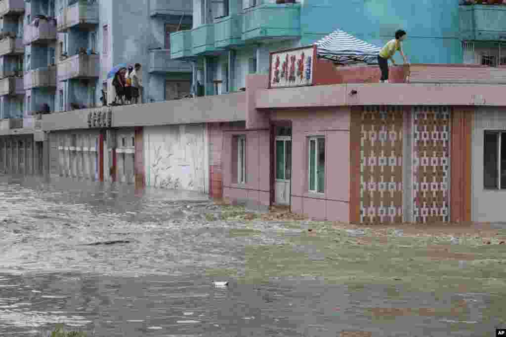 평안남도 안주시에서 불어난 물을 피해 건물 위로 대피한 주민들.