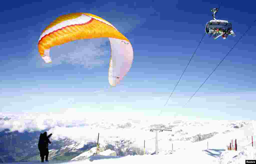 A paraglider prepares to start on a sunny autumn day at the Mount Titlis skiing area near the Alpine resort of Engelberg, Switzerland, Oct. 13, 2020.