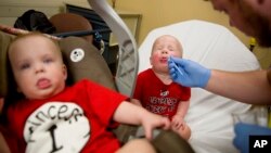 Kilian Daugherty, 1, gets his nose swabbed for the flu by emergency department technician Jake Weatherford as his sister Madison, left, waits to be examined as well for flu symptoms at Upson Regional Medical Center in Thomaston, Georgia, Feb. 9, 2018.