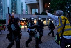 Un anciano trata de bloquear a los policías que llegan a arrestar a manifestantes en Tung Chung, cerca del aeropuerto de Hong Kong. Domingo 1 de septiembre de 2019.