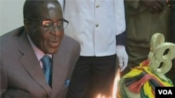 Presiden Zimbabwe Robert Mugabe meniup lilin saat merayakan Ulang Tahun ke-88 (21/2).