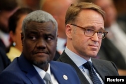 FILE - Moussa Faki Mahamat, African Union Commission Chairperson, left, attends a Summit in Berlin, Germany, June 13, 2017.