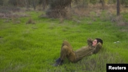 Seorang tentara sukarela Israel melewatkan waktunya dengan bersantai di padang rumput dekat perbatasan Israel di sebelah utara Gaza pasca diumumkannya gencatan senjata (22/11). Israel telah melonggarkan sejumlah pembatasan di wilayah perbatasan pasca gencatan senjata.