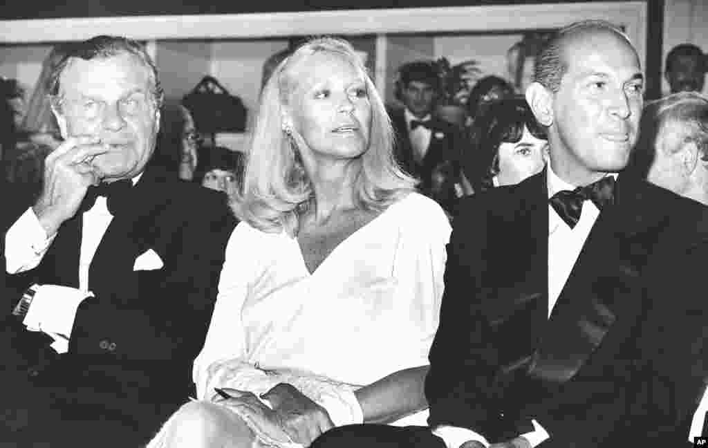 Joan Bennett Kennedy sits between fashion designers Bill Blass (left) and Oscar de la Renta at a gala fashion show to benefit the Wang Center for the performing arts in Boston, Sept. 20, 1983. 