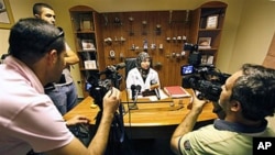 Lebanese Dr. Iman Sharara, center, tells journalists that dozens of women stormed her clinic as international investigators were visiting her, south of Beirut, Lebanon, 27 Oct 2010