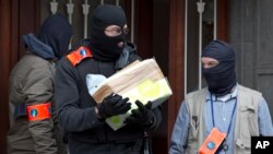 比利时警察在布鲁塞尔搜查安德莱赫特居民区的一所房屋后离开。（2016年3月23日）
