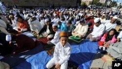 Muslim devotees take part in a special morning prayer to start their Eid al-Fitr festival, which marks the end of Muslim's holy fasting month of Ramadan, outside the Baitul Ma'Mur Mosque in Brooklyn, New York, 20 Sep 2009