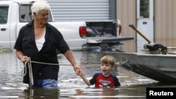 지난 15일 미국 루이지애나주 세인트애먼트에서 주민들이 홍수로 불어난 물을 피해 안전한 곳으로 이동하고 있다.