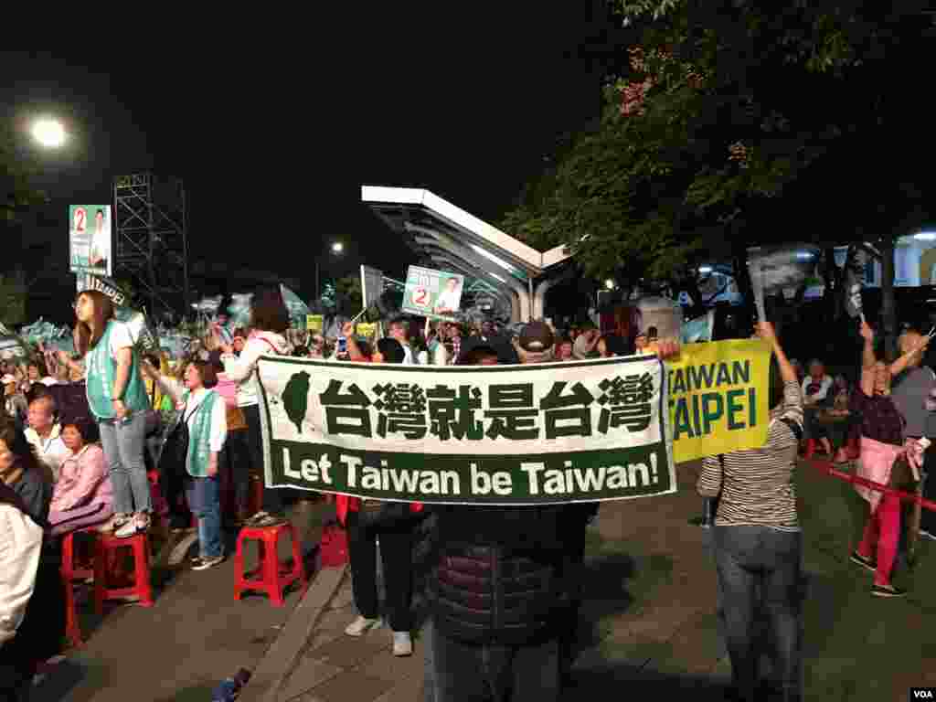 民進黨籍台北市長候選人姚文智11月21日的造勢晚會上,一名支持者打出橫額。 (美國之音許寧拍攝)