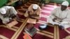 Les musulmans lisent un Coran après une prière du vendredi dans une mosquée d'Abidjan pendant le mois sacré du Ramadan, le 18 mai 2018 
