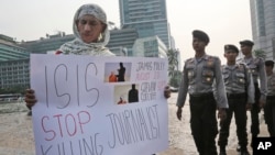 지난 5일 인도네시아 자카르타에서 경찰이 지켜보는 가운데, 한 남성이 테러단체 ISIL의 무고한 민간인 기자 살해를 규탄하는 시위를 하고 있다.. (자료사진)