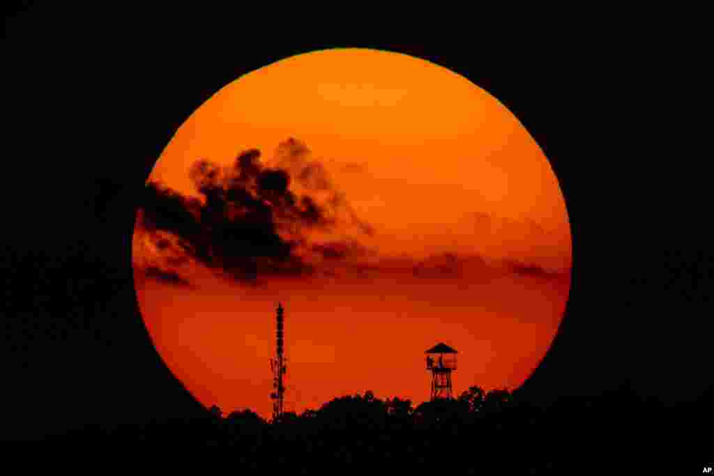 The setting sun frames a look-out tower and a telecommunication transmission tower near Salgotarjan, some 100 kilometers northeast of Budapest, Hungary, Aug. 22, 2018.