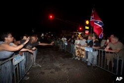 Anti-monument protesters Rose Hunter, left, and her son, Deshaun Washington, make their case with pro-monument supporters, right, near the statue of Confederate Gen. P.G.T. Beauregard as the statue was prepared for removal from the entrance to City Park in New Orleans, May 16, 2017.