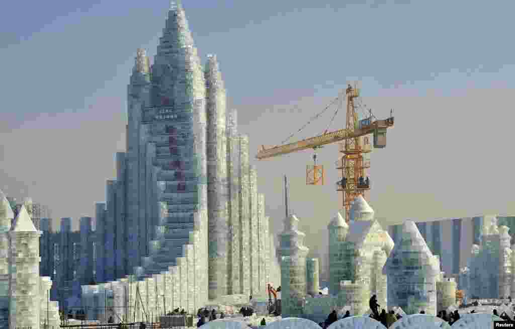 Workers and a crane are seen next to a newly-built ice sculpture castle ahead of the 30th Harbin Ice and Snow Festival, in Heilongjiang province, China. According to festival organizers, nearly 10,000 workers were employed to build the sculptures, which require about 180,000 square meters of ice and 150,000 square meters of snow. 