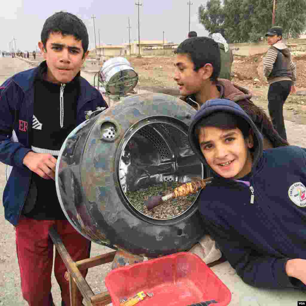 Kids toasting sunflower seeds to sell. When Islamic State was in control, people were not allowed to sell sunflower seeds. (K. Omar for VOA)