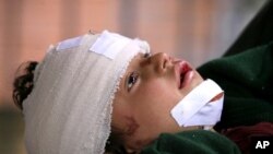 A girl, injured in a Nowshera mosque bomb explosion, is brought to the Lady Reading hospital for treatment in Peshawar, March 4, 2011