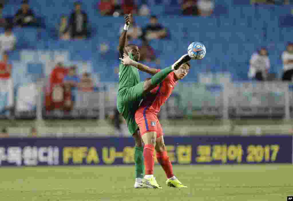 Pemain Nigeria Erimuya Saturday Keigo (kiri) berebut bola dengan pemain Korea Selatan Hwang Hee-chan pada pertandingan Turnamen Sepakbola U-23 di stadion kota Suwon, Korea Selatan.