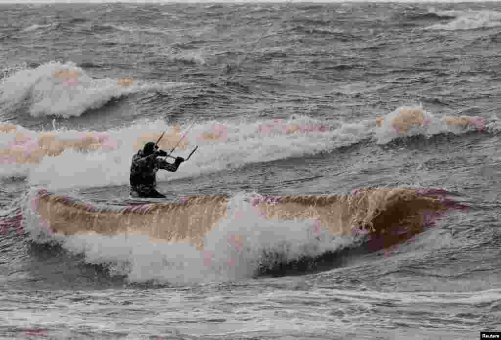 A man kiteboards in the sea in Saulkrasti, Latvia.